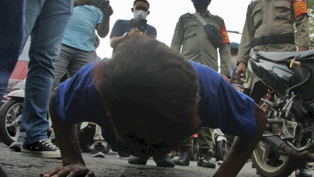Satpol PP Makassar menghukum Pus-up warga yang melintas di perbatasan tanpa menggunakan masker, Minggu (12/7/2020). (ist) 