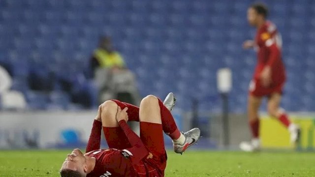 Kapten Liverpool Jordan Henderson tampak meringis kesakitan memegangi lutut kirinya ketika cedera di tengah laga lanjutan Liga Inggris melawan Brighton & Hove Albion yang digelar tanpa penonton karena pandemi COVID-19 di Stadion Amex, Brighton, Inggris, Rabu (8/7/2020). (ANTARA/REUTERS/POOL/Paul Childs)