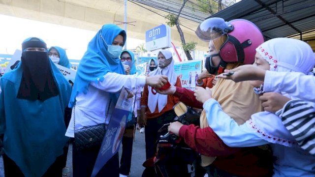 Ketua PKK Kota Makassar, Rossy Timur Wahyuningsih dan anggota PKK turun ke jalan membagikan masker kepada warga, Minggu (9/8/20). ()