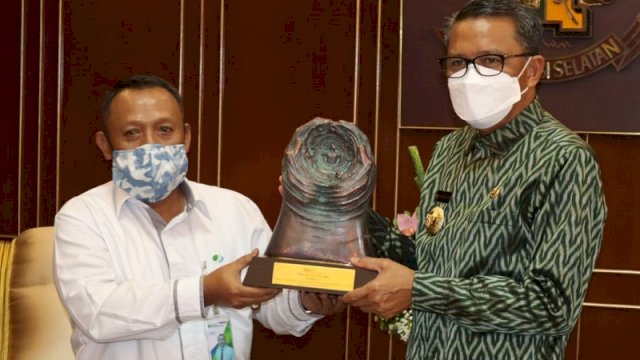 Direktur Utama BPJS Wilayah Sulsel, Maluku Toto Suharto menyerahkan Piala Paritrana Award dan diterima Gubernur Sulsel Nurdin Abdullah di ruang kerjanya, Senin (28/9).