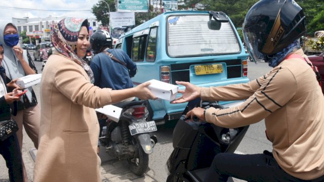 Politisi partai Gerindra Kota Makassar, Nunung Dasniar berbagi makanan gratis kepada pengguna jalan, di Kecamatan Tamalanrea, Jumat (27/11/2020).