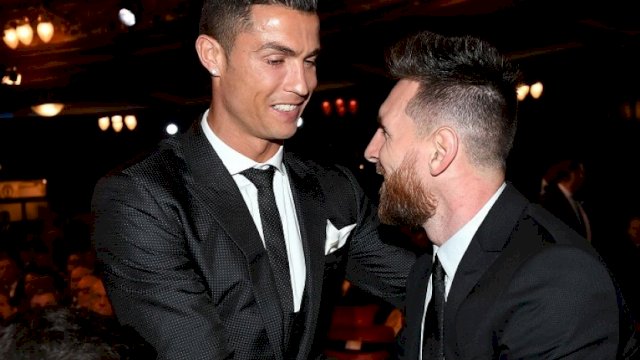 Lionel Messi (kanan) dan Cristiano Ronaldo bersalaman dalam acara penghargaan FIFA di London, Senin (23/10). (Foto: EPA-EFE/ANDY RAIN)