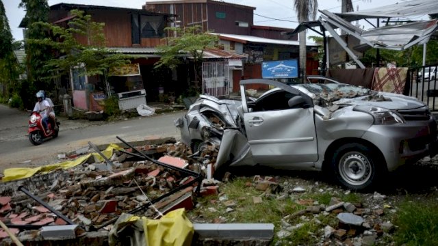 Sebuah mobil rusak akibat gempa bumi di Kabupaten Mamuju, Sulawesi Barat, Minggu (17/1/2021). Gempa bumi berkekuatan magnitudo 6,2 yang terjadi pada Jumat (15/1) dini hari tersebut mengakibatkan 81 orang meninggal dunia. ANTARA FOTO/Abriawan Abhe/wsj.