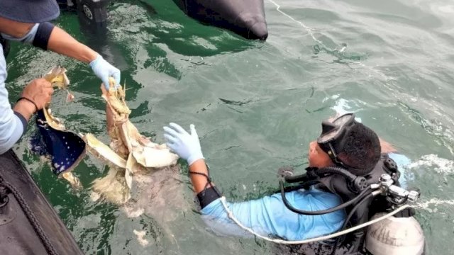 Tim penyelam dari Satuan Komando Pasukan Katak (Kopaska) TNI Angkatan Laut mengevakuasi serpihan pesawat yang ditemukan dalam pencarian pesawat Sriwijaya PK-CLC SJ182, yang jatuh di perairan Kepulauan Seribu, Minggu (10/1/2021). (ANTARA/Fauzi Lamboka)