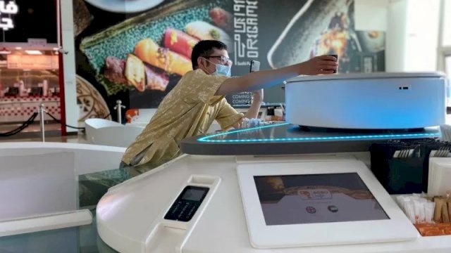 Konsumen mengambil minuman yang dipersiapkan robot di kafe di Dubai Festival City, Uni Emirat Arab, 7 Februari 2021. ANTARA/REUTERS/ABDEL HADI RAMAHI.