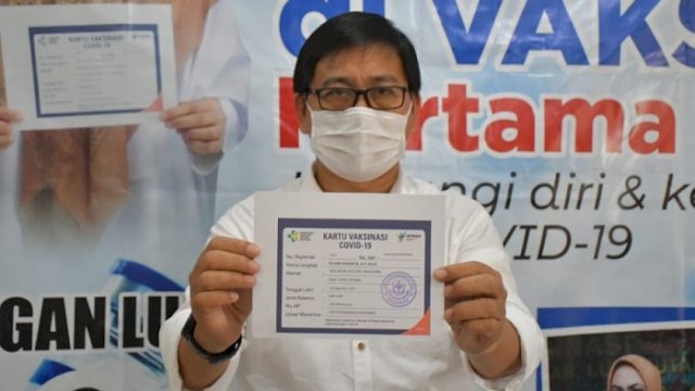 Wakil Bupati Luwu Utara, Suaib Mansur menunjukkan kartu usai menerima suntikan vaksim. ()