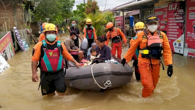 Petugas melakukan evakuasi warga terdampak banjir. ()
