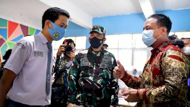 Plt Gubernur Sulawesi Selatan (Sulsel), Andi Sudirman Sulaiman, berbincang-bincang dengan salah seorang siswa saat launching pembelajaran tatap muka terbatas SMA/SMK/SLB di SMA Negeri 21 Makassar, Jalan Tamalanrea Raya, Jumat (9/4/2021). 