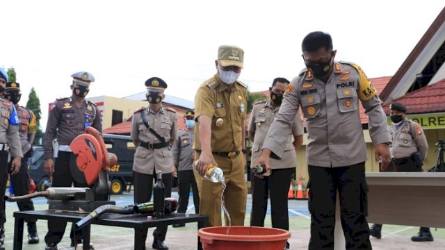 Bupati Luwu Timur H Budiman dan Kapolres Luwu Timur, AKBP Indratmoko S.Ik, memusnahkan barang sitaan minuman keras (miras) dan knalpot racing yang dilakukan Polres Luwu Timur di halaman Kantor Polres Luwu Timur, Malili, Jumat (16/4/2021).
