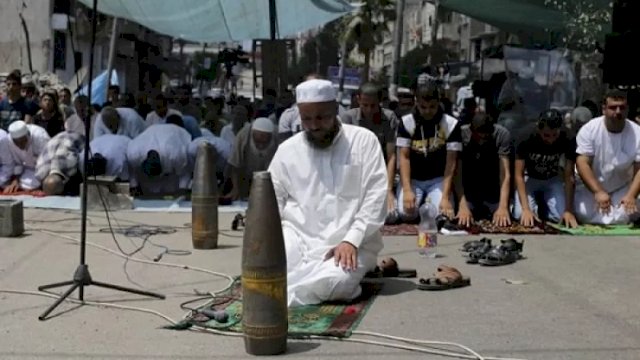 Rudal yang belum meledak dan telah dijinakkan, yang menurut warga Palestina ditembakkan oleh pasukan Israel dalam serangan Israel, diketakkan di dekat jamaah yang melaksanakan ibadah Salat Jumat di dekat puing-puing sebuah masjid yang menurut saksi mata hancur akibat serangan udara Israeldi Jalur Gaza, Palestina, Jumat (15/8). ANTARA FOTO/ REUTERS/Ibraheem.