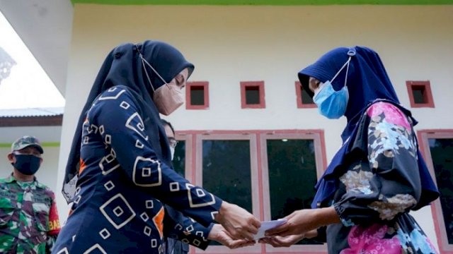 Bupati Luwu Utara, Indah Putri Indriani saat menyerahkan bantuan kepada korban terdampak banjir di Desa Tamboke Kec Sukamaju.