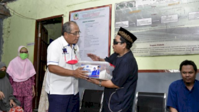 Ilham Arief Sirajuddin saat menyerahkan bantuan. 