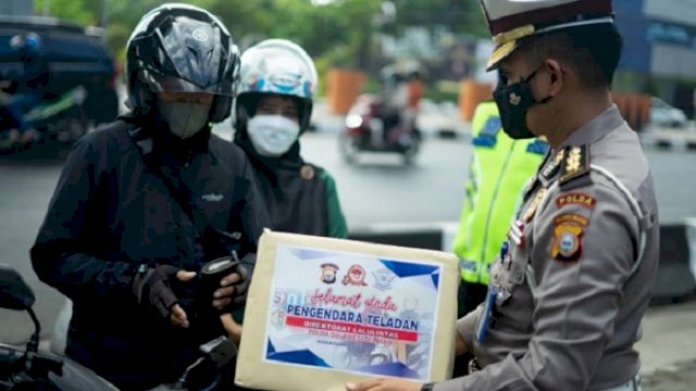 Kasubdit Regident Ditlantas Polda Sulsel memberikan hadiah kepada pengendara teladan.