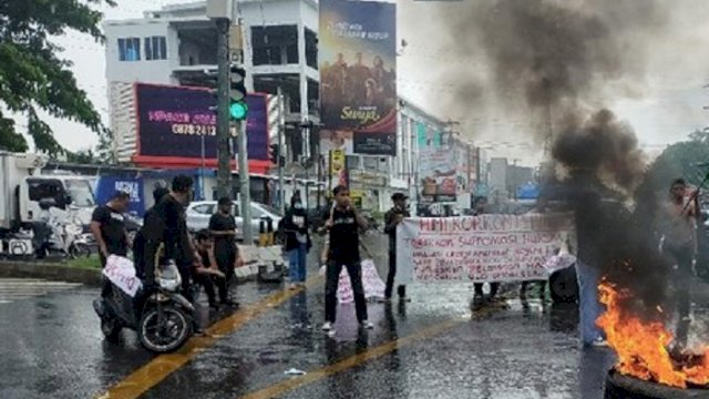 Massa melakukan aksi demo di lampu merah pertigaan Tello. (int)
