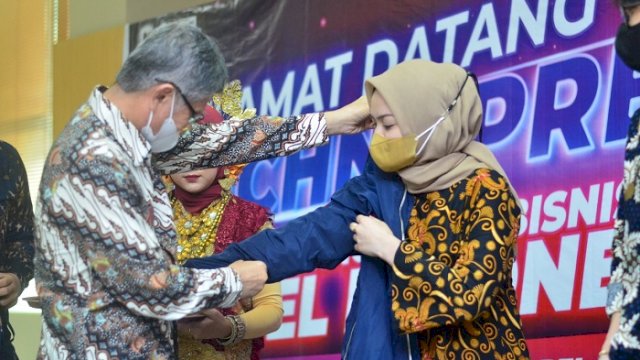 Ketua Pembina Yayasan Pendidikan Nobel Indonesia Badaruddin saat memasangkan almamater ke mahasiswa baru.