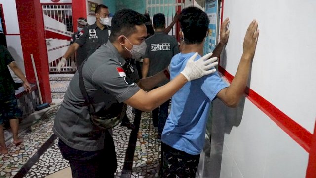 Petugas dari Tim Satops Patnal Kemenkumham Sulsel tengah memeriksa salah satu tahanan di Rutan Makassar, Selasa (14/12/2021) malam.