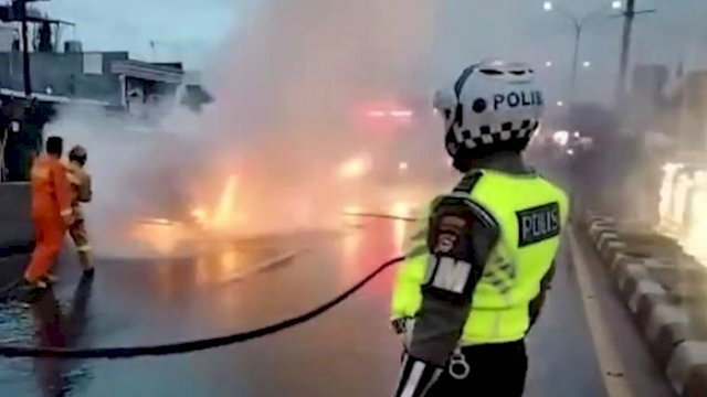 Petugas dari Dinas Pemadam Kebakaran Kota Makassar berusaha memadamkan api yang membakar sebuah angkutan umum atau petepete di jembatan flyover, Jalan Urip Sumoharjo, Kota Makassar, Kamis (13/1/2022).