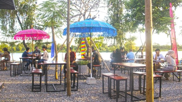 Pengunjung menikmati suasana Cafe Ruang Tunggu, di Danau Tanjung Bunga Makassar, Kamis (24/3/2022).