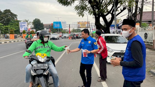 Wakil Ketua KNPI Sulsel, Robby Ukkas membagikan takjil kepada pengendara yang melintas, di Jl AP Pettarani Makassar, Jumat (8/4/2022).