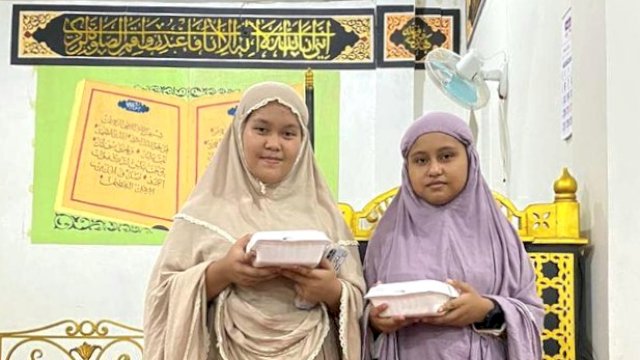 Warga menerima menu buka puasa Laskar Anak Lorongna.