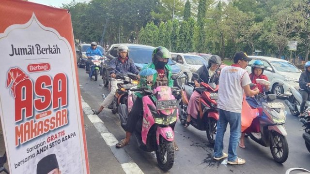Relasan ASA membagikan nasi kuning gratis kepada masyarakat yang melintas di fly over, Makassar, Jumat (12/7/2024).