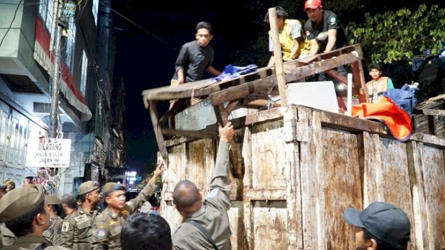 Petugas melakukan penertiban pasar tumpah di kawasan Jalan Veteran Utara, Minggu dini hari (24/5/2026).